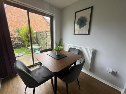 a dining room with a table and chairs and a window at Restful Riverside Home in Lincolnshire