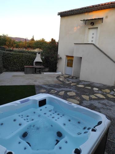 una bañera de hidromasaje en el patio de una casa en La Remise de Guytou et Spa en Cheval-Blanc