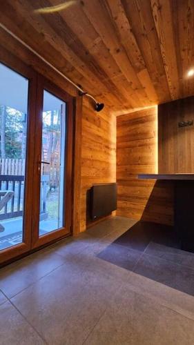 une pièce vide avec une grande fenêtre dans une maison en bois dans l'établissement Auron, Centre, Location de Ski Gratuite, Les 3 Lys, à Saint-Étienne-de-Tinée