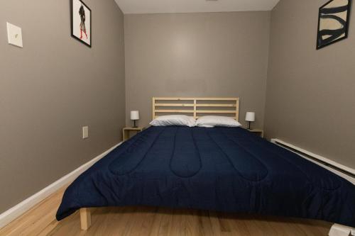 a bedroom with a large blue bed with two pillows at Pleasing 4- Bed Apartment Close to NYC in Jersey City