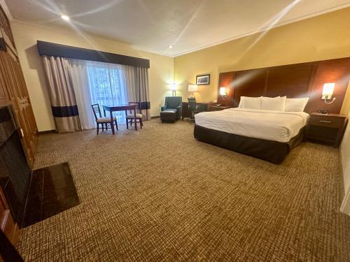 a hotel room with a bed and a table and chairs at Comfort Inn Monterey Peninsula Airport in Monterey