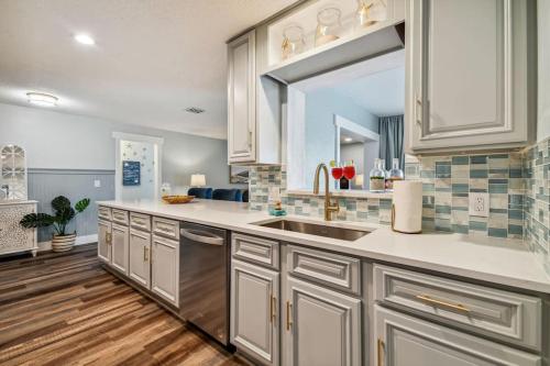 a large kitchen with white cabinets and a sink at Luxury heated-pool home blocks from the beach in Tarpon Springs