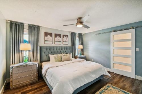 a bedroom with a bed and a ceiling fan at Luxury heated-pool home blocks from the beach in Tarpon Springs