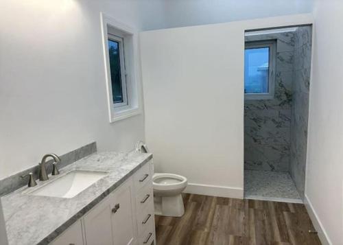 W łazience znajduje się umywalka, toaleta i prysznic. w obiekcie Twin Coves Tranquility: Private Beachfront Estate w mieście North Palmetto Point