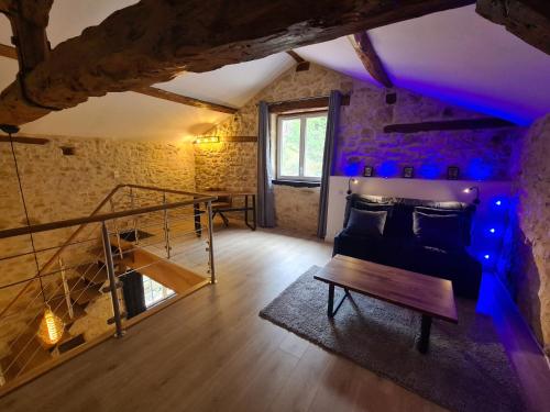 een woonkamer met een bank en een tafel bij La Noz Vad, Superbe maison Perigourdine in Saint-Cybranet