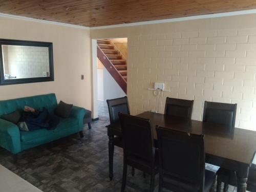 uma sala de estar com uma mesa e um sofá verde em casa Galilea em Rancagua
