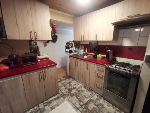 uma cozinha com armários de madeira e um forno com placa de fogão em casa Galilea em Rancagua