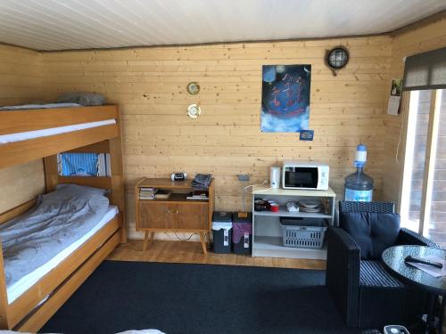 Saare-Toominga camping house في Väike-Rakke: غرفة صغيرة مع سرير بطابقين وميكروويف