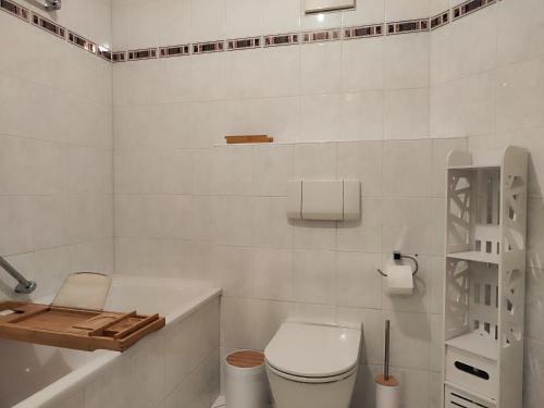 een witte badkamer met een toilet en een bad bij 2 Zimmer Wohnung, Küche, Bad, Balkon, Tiefgarage, Netflix in Alzey