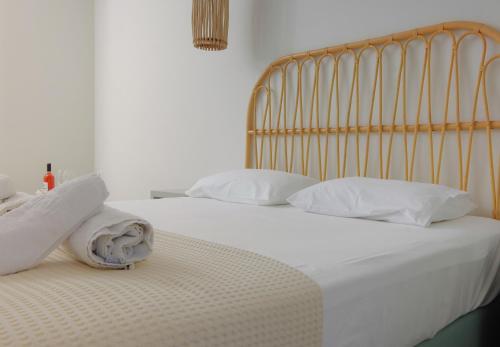 a bed with white sheets and pillows on it at Remvi in Galissas