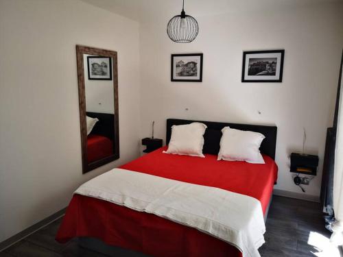 ein Schlafzimmer mit einem rot-weißen Bett und einem Spiegel in der Unterkunft Cannes Cosy Oasis in Cannes