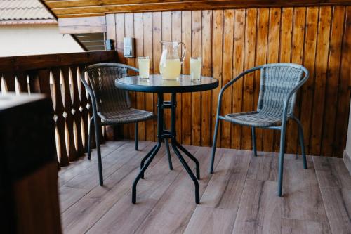 EDANT HOUSE في Bumbesti Pitic: طاولة مع كرسيين وكأسين من عصير البرتقال