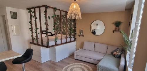 a living room with a couch and a mirror at New jungle studio cœur de ville in Pont-à-Mousson