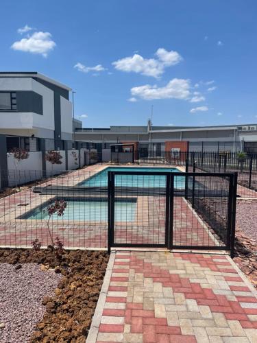 una recinzione attorno a una piscina di fronte a un edificio di Sunshine Villa a Gaborone