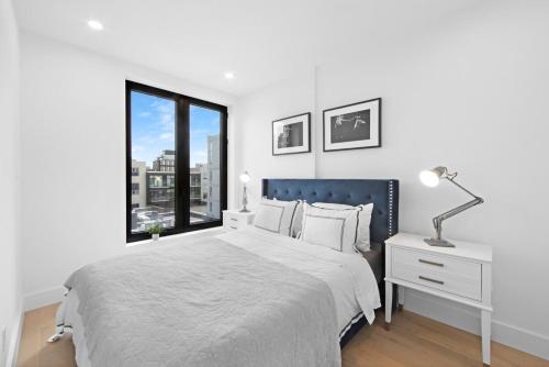 a white bedroom with a large bed and a window at 149BK-501 NEW Prime greenpoint 2BR WD in unit in Brooklyn