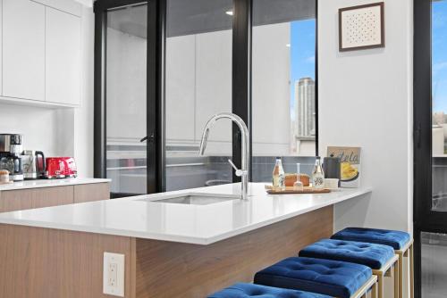 a kitchen with a white counter and blue stools at 149BK-501 NEW Prime greenpoint 2BR WD in unit in Brooklyn