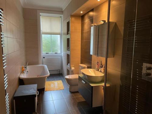 a bathroom with a sink and a tub and a toilet at Edenfield House, Springfield, Fife in Cupar