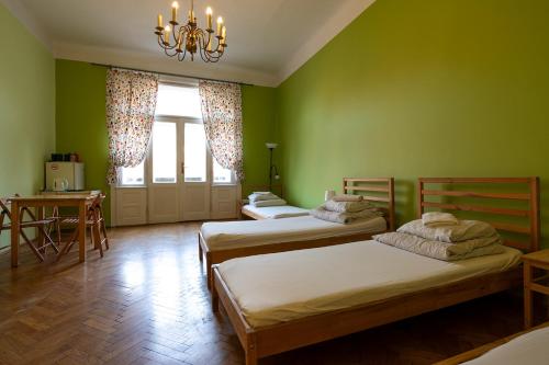 two beds in a room with green walls at Trzy Kafki Private Rooms in Kraków