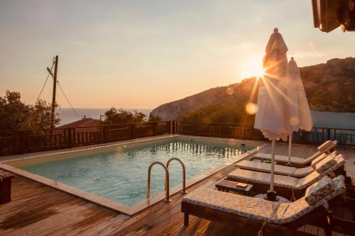 a swimming pool on a deck with the sun setting at Likya House - Deniz ve Doğa Manzaralı, Havuzlu in Patara