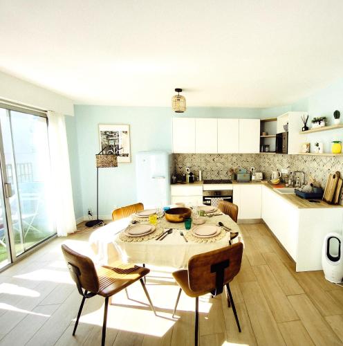 une cuisine avec une table et des chaises dans une pièce dans l'établissement Elégant appartement 4 couchages et parking - 5mn de la plage et des commerces, à Arcachon