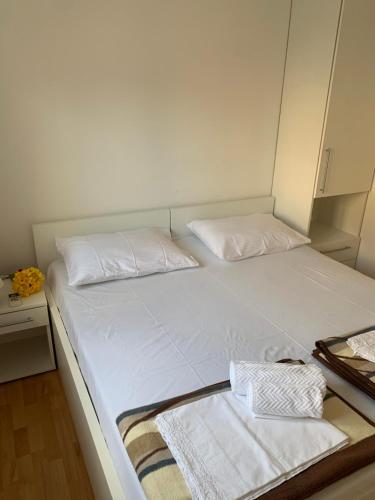 a bed in a room with two white pillows at Apartments ORCHIDEA 1 in Dubrovnik