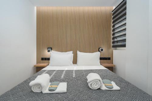 een slaapkamer met een bed met handdoeken erop bij Urban Chic Apartment in the Heart of Athens in Athene