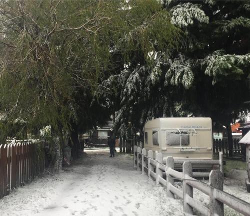 a camper parked next to a fence in the snow at Mapunre in Malalcahuello