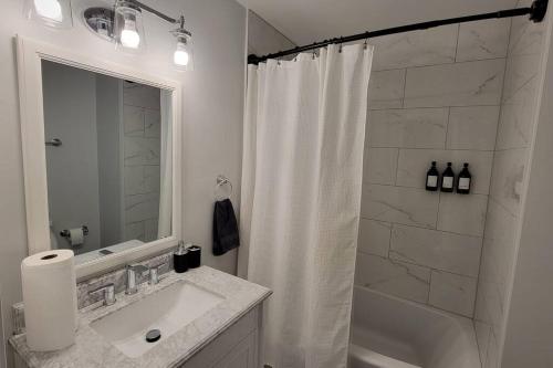 a bathroom with a white shower curtain and a sink at Tranquil Retreat: Short-Term Luxury Rental in Atlanta