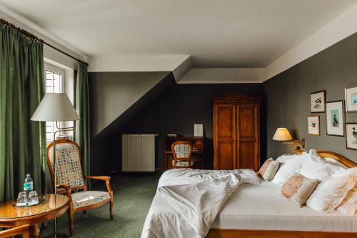 Hotel Villa Rainer في بويرشاك آم فورثيرسي: غرفة نوم بسرير وطاولة وكراسي