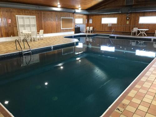 One Bedroom Unit at Acadia Village Resort في إلسورث: مسبح كبير في صالة رياضية فيها طاولات وكراسي