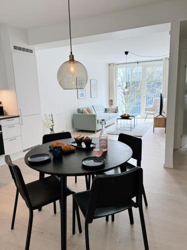 uma sala de jantar e sala de estar com mesa e cadeiras em Modern city center apartment em Arhus