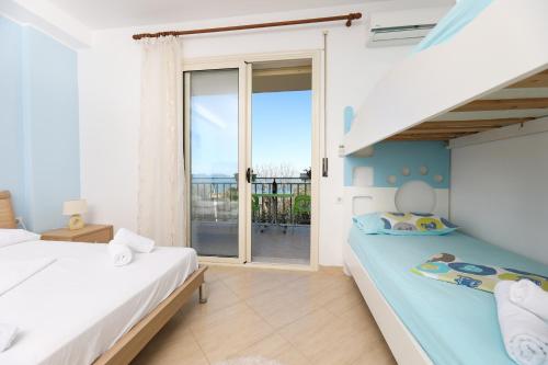 Un dormitorio con dos camas y un balcón. en Lorel's Homes, en Vlorë