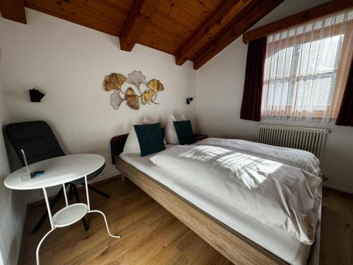 a small bedroom with a bed and a table at Pension Lederergütl - Jokercard & Parkplatz inkl in Saalbach Hinterglemm