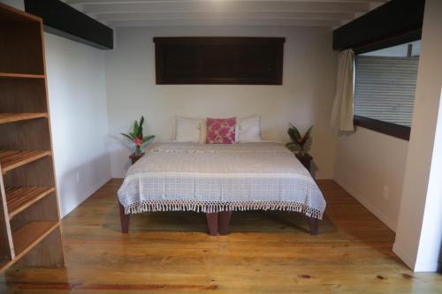 1 dormitorio con 1 cama y TV en la pared en Roam Yoga & Wellness Lodge, en Bocas Town