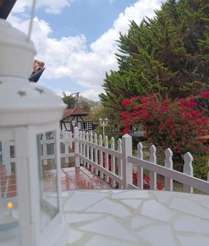 a white picket fence in front of a yard at Cabañas Hessen - Colonia Tovar para 2 personas in El Tigre