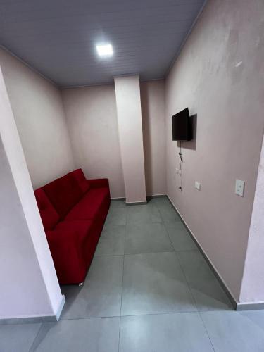 ein Wohnzimmer mit einem roten Sofa und einem TV in der Unterkunft Hospedaje Lucas in El Soberbio