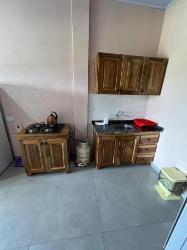 eine Küche mit zwei Waschbecken und Holzschränken in der Unterkunft Hospedaje Lucas in El Soberbio