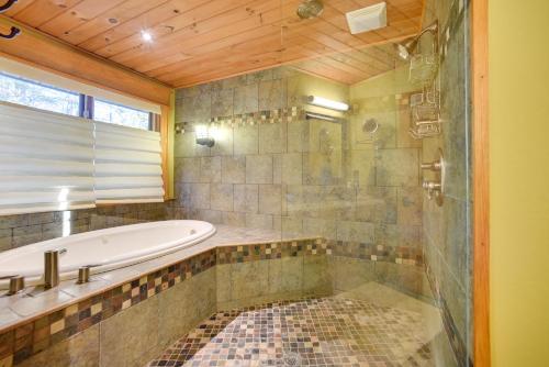 La grande salle de bains est pourvue d'une baignoire et d'une douche. dans l'établissement Luxurious Lakefront Paradise in Scottsboro with Dock, à Scottsboro