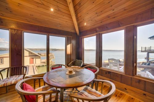 a dining room with a table and chairs and windows at Luxurious Lakefront Paradise in Scottsboro with Dock in Scottsboro