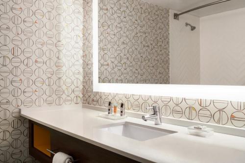a bathroom with a sink and a mirror at Holiday Inn Orlando International Airport by IHG in Orlando