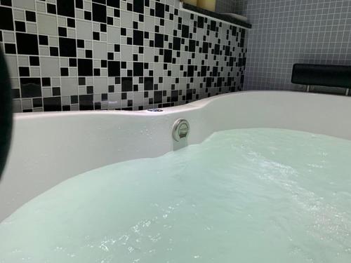 a bath tub filled with water in a bathroom at Maravilhoso apartamento 2 quartos com ofurô Porto da Barra Salvador Summer Barra Flat in Salvador