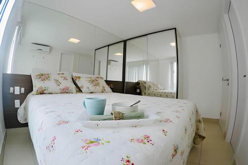 Un dormitorio con una cama grande y una bandeja. en Apt à Beira-Mar Cabo Branco c ótima área de lazer, en João Pessoa