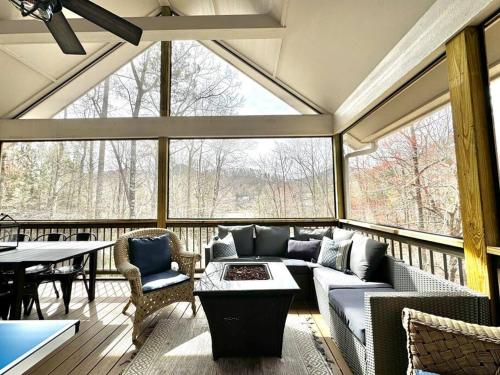 a screened in porch with a couch and a table at The Cove Retreat- Hot Tub/Screened Porch/Game Room in Lake Lure