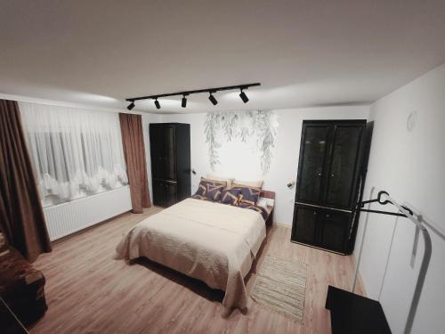 a bedroom with a large bed and a window at BANJANSKI RAJ in Arandjelovac