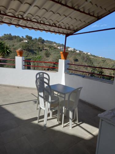einen Tisch und Stühle auf dem Dach eines Hauses in der Unterkunft Casa del aire libre in Moya