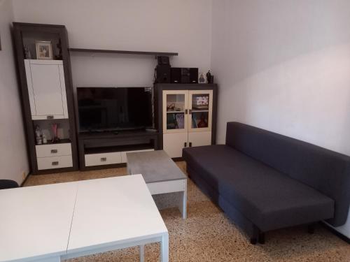 sala de estar con sofá, mesa y TV en Casa del aire libre, en Moya