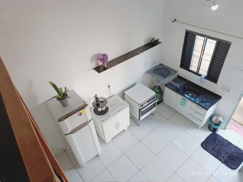 eine Küche mit weißen Fliesenböden und einem Fenster in der Unterkunft Apartamento Loft 03 Ponta Porã MS. in Ponta Porã