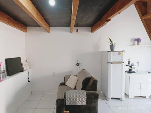 ein Wohnzimmer mit einem Sofa und einem Kühlschrank in der Unterkunft Apartamento Loft 03 Ponta Porã MS. in Ponta Porã