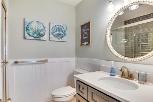 ein weißes Badezimmer mit einem Waschbecken und einem Spiegel in der Unterkunft Atlantic Beach Home with Deck and Grill Walk to Beach in Atlantic Beach