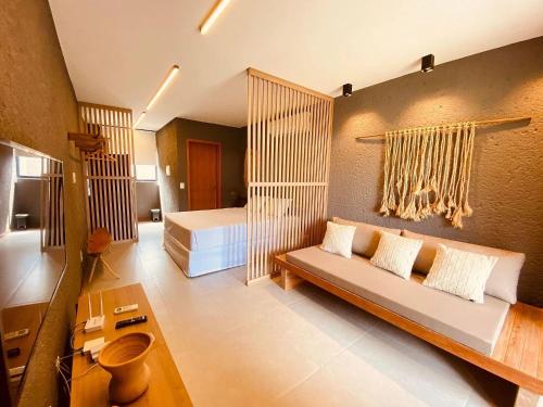 a living room with a couch and a bed at Villas Manatee Milagres por Quarto à Vista in Pôrto de Pedras